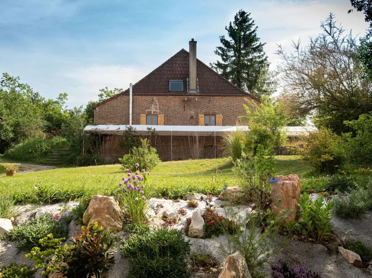 Façade en briques et jardin de l’Écolieu Ô Saveur de l’Instant